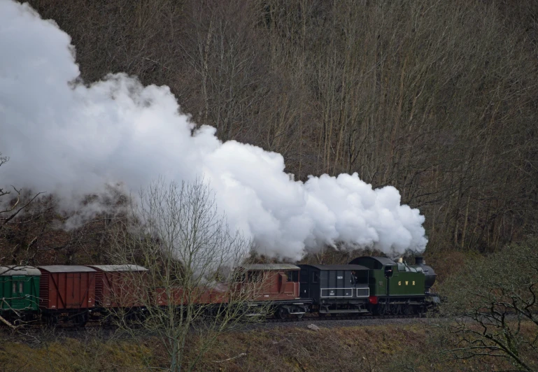 steam rises from the locomotive as it travels along tracks
