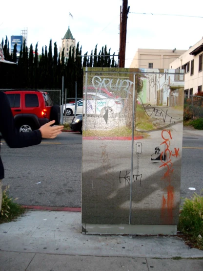 graffiti is sprayed on a metal cabinet at an intersection