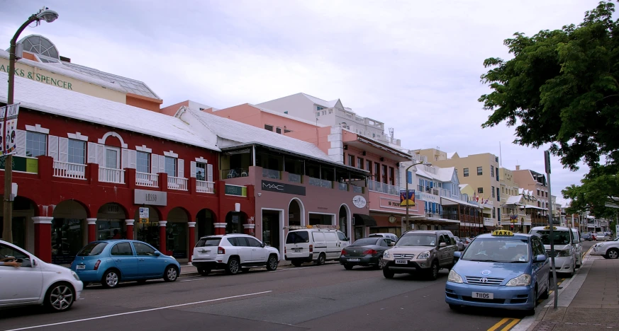 several cars are driving down the street next to colorful buildings