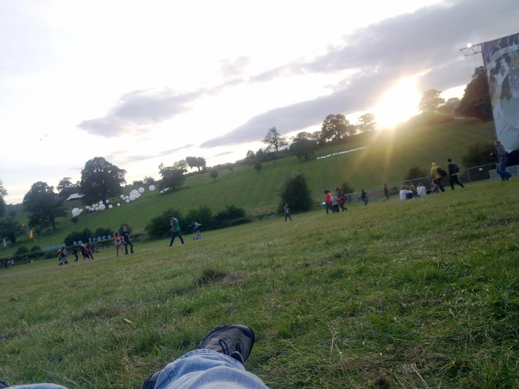 a person is laying in the grass while kites fly