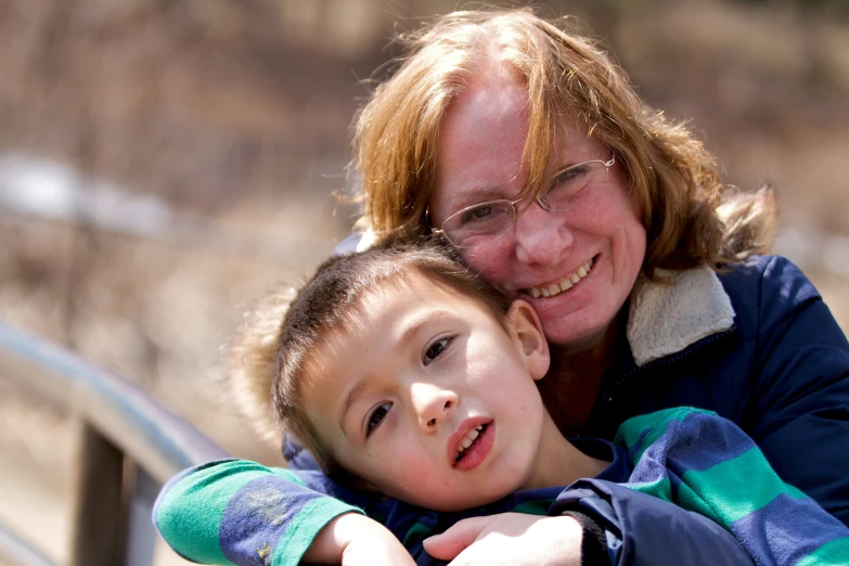 a woman hugging her child with a smile on his face