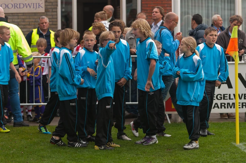 boys'soccer team in front of a building with fans