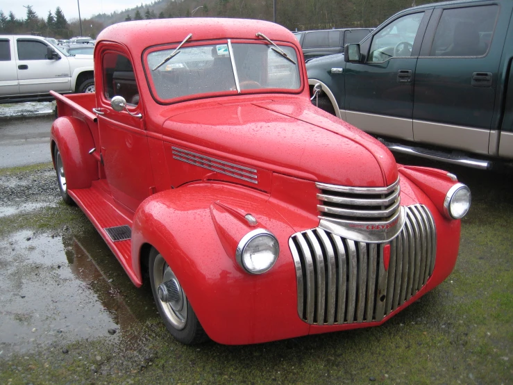 an old truck in a parking lot with other cars