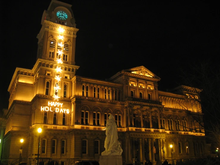 people gathered at night in front of an illuminated building