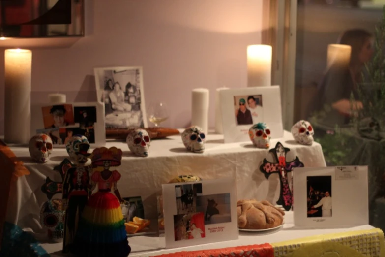 many different skulls are on a table in front of candles