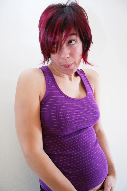 a pregnant woman posing in a purple top