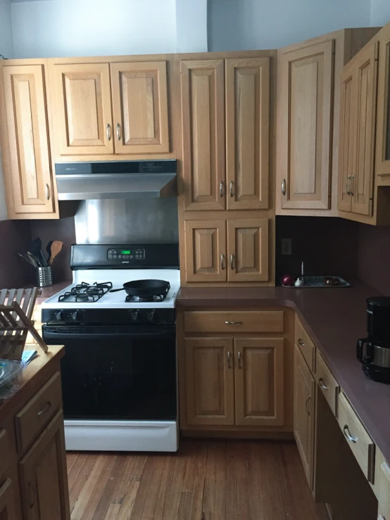 an empty kitchen with light wood cupboards and an oven