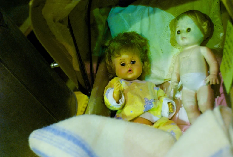two doll like children sleeping side by side with a baby