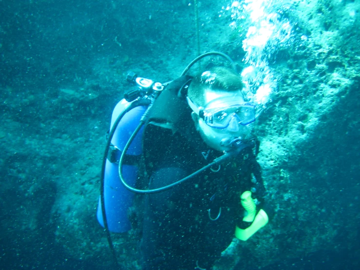 a person scubas on the ocean floor in a blue suit