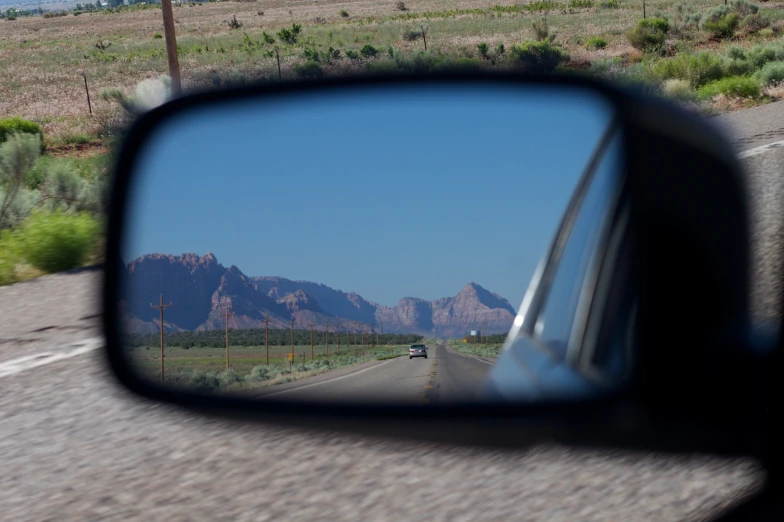 the view of mountains in a rear view mirror