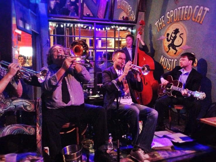 several people playing instruments while sitting in chairs