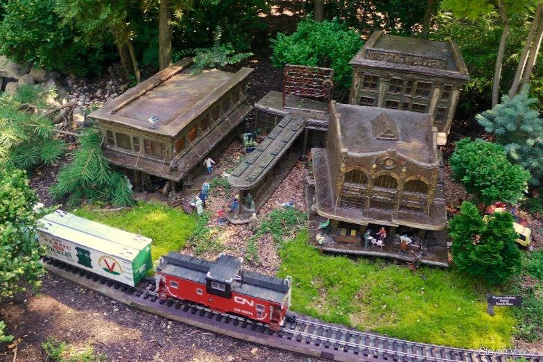 the toy train runs on the tracks in front of the house