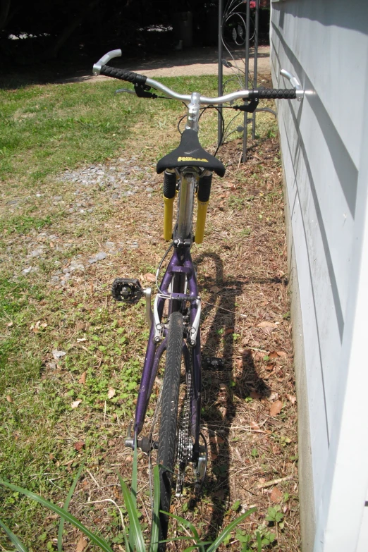 a bike with bars parked by the wall of a house