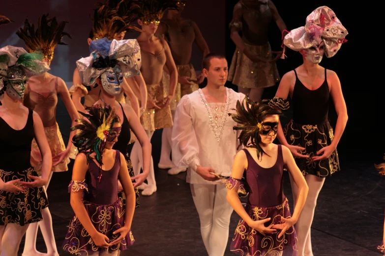 a group of dancers with masks on their heads and wearing masks