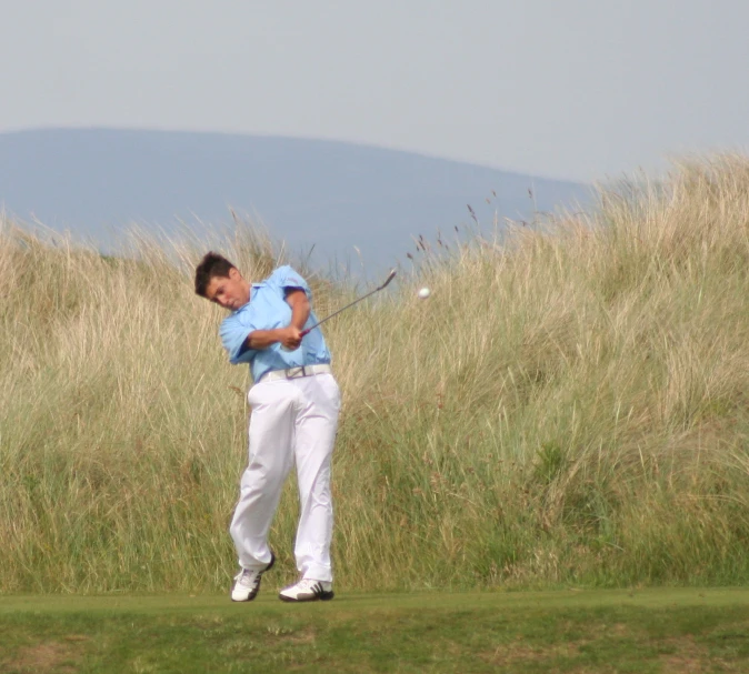 a person playing golf on the grass