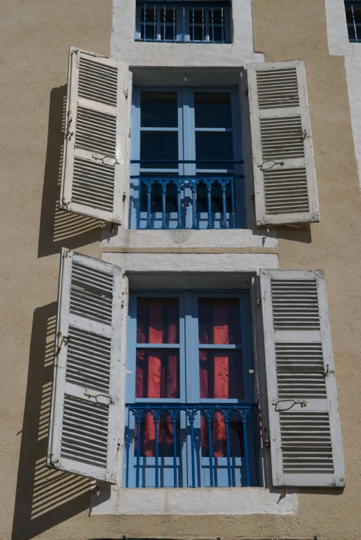 an image of two buildings with shutters open