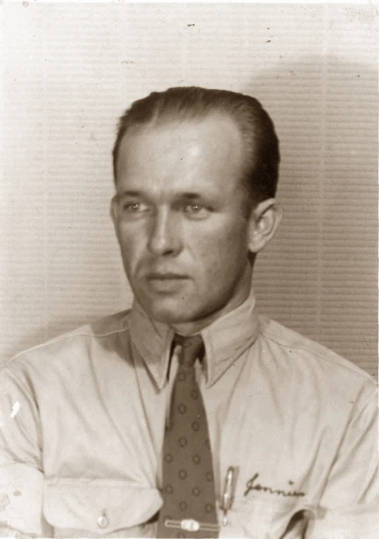 a black and white po shows a man in a dress shirt and tie
