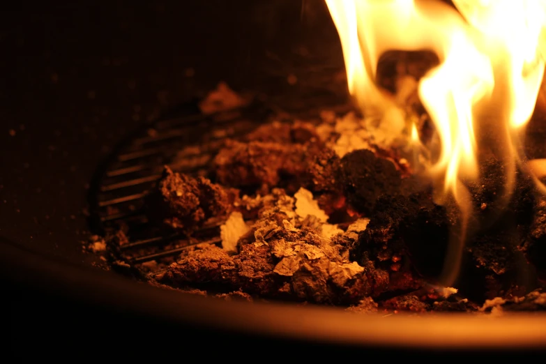 two  flames are blazing over a dish of meat