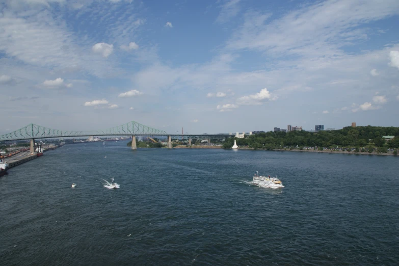 a boat passing under the bridge on a sunny day