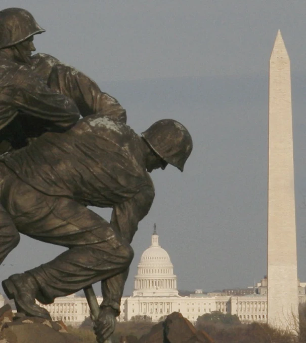 a statue of a soldier with the washington monument in the background