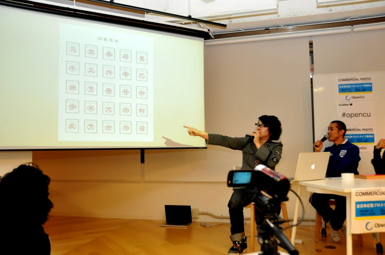 a group of people on chairs in front of a projection screen