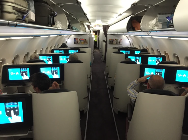 two men in seats on airplanes looking at their monitors