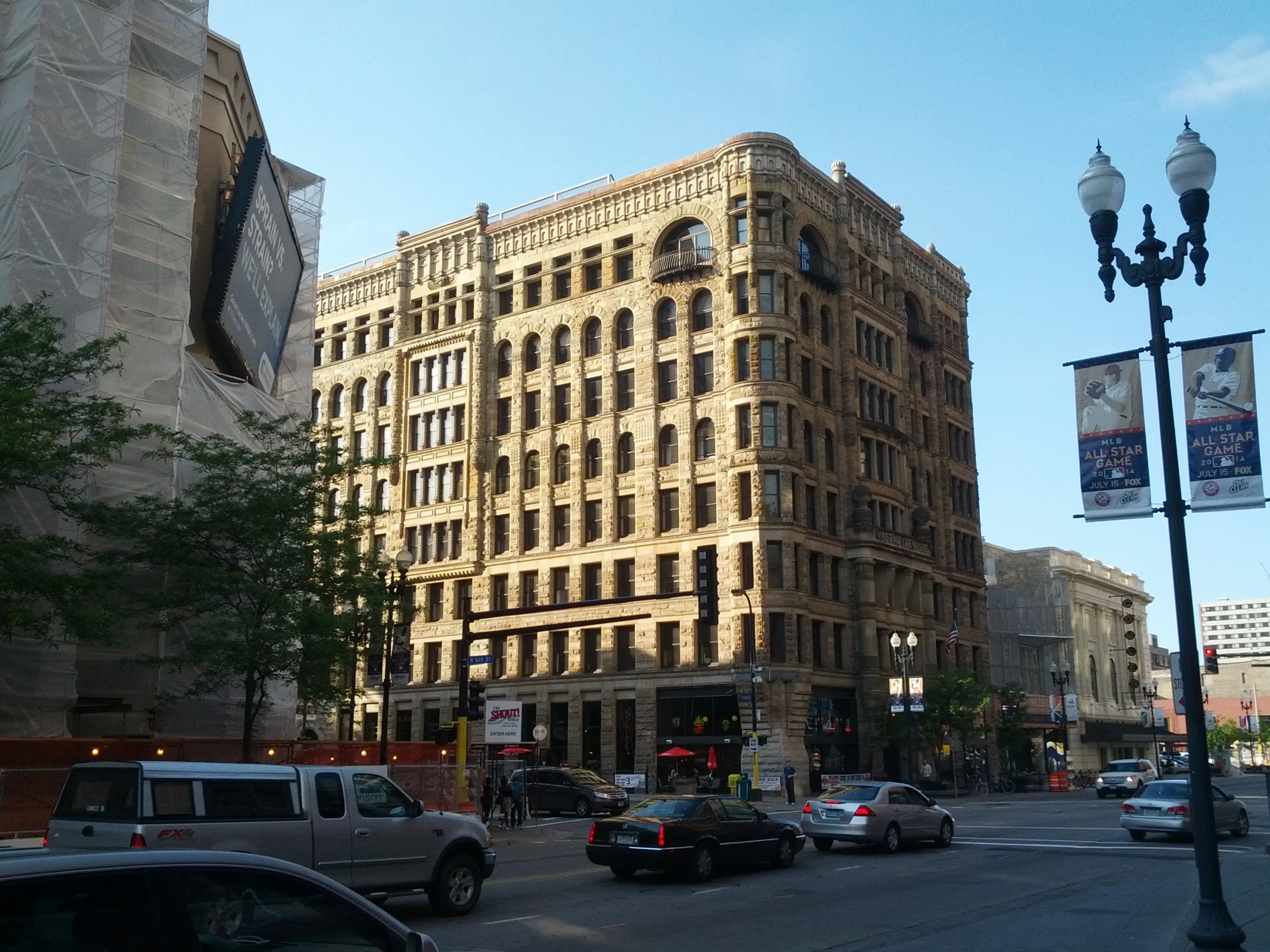 a tall brown building sitting next to traffic