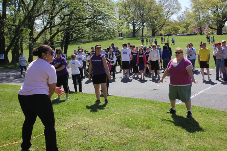 a group of people are standing on grass outside