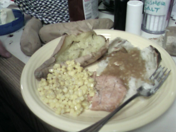 a plate topped with meat, mashed potatoes and corn