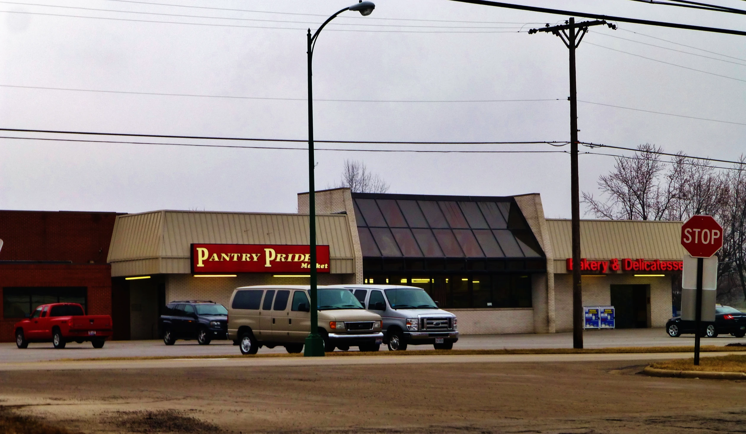 a commercial store with multiple cars driving along the street