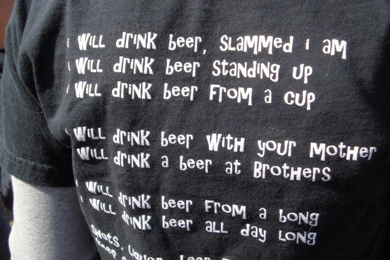 a man with an interesting tee - shirt that says will drink beer, scanner i am