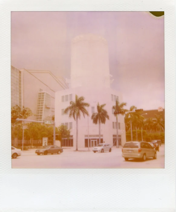 the po is polaroidic and shows a building with a palm tree in the middle