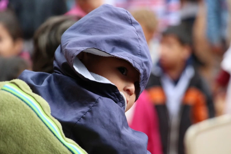 a boy is hiding his face with an umbrella on