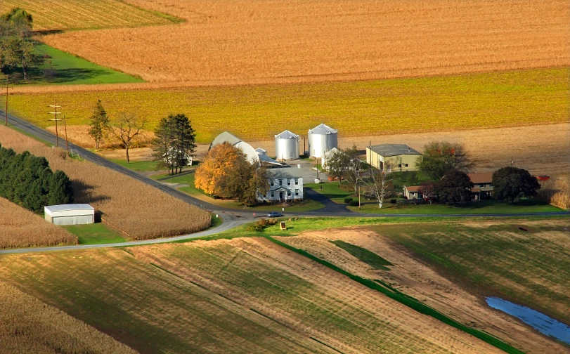 an aerial po of a farm, roads and several barns