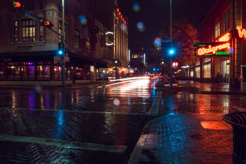 a wet city street is pictured in the evening