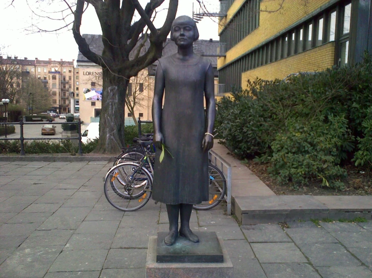 a statue in front of a building in front of a bike