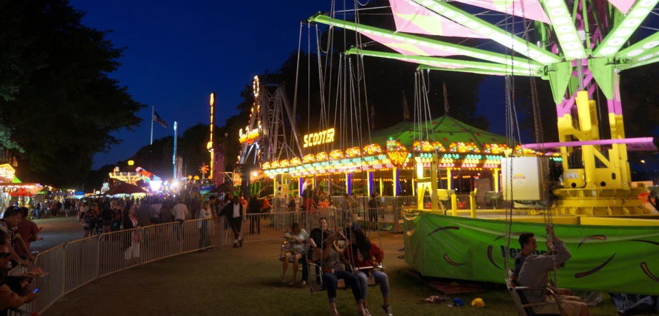 people and fair rides are lit at night