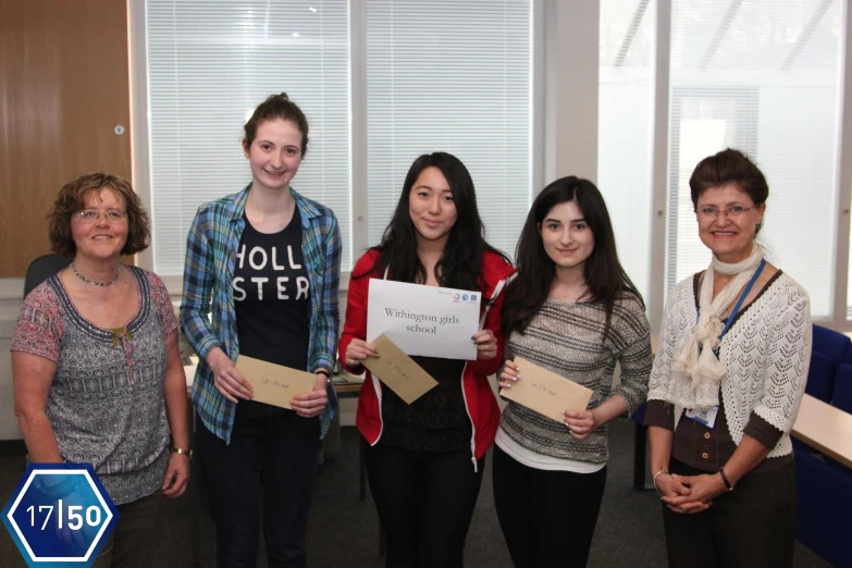 several people standing around holding up some paper