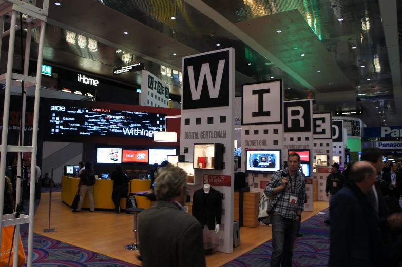 people at an indoor trade event looking at display items