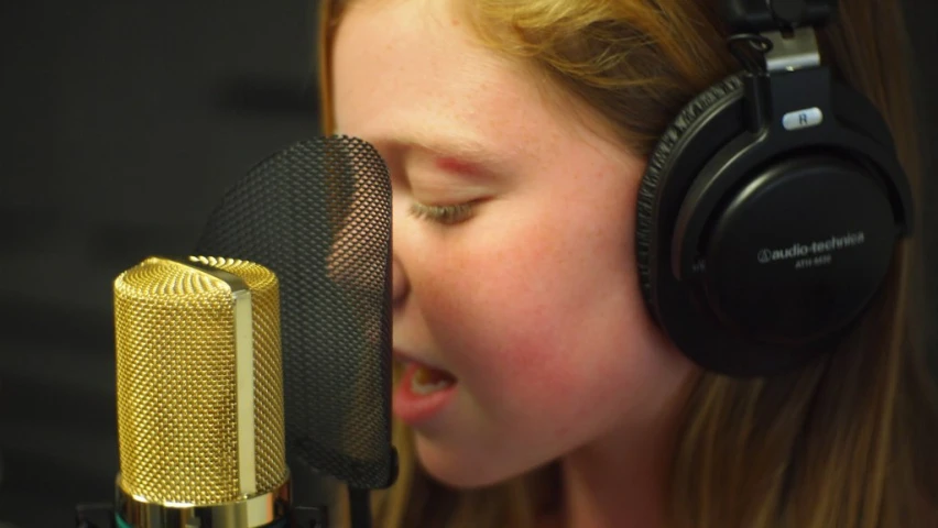 a young woman with headphones is singing