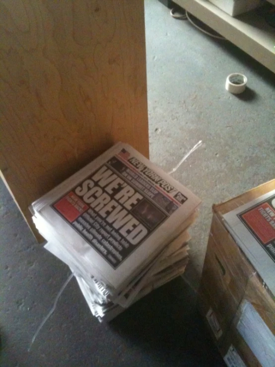 a stack of newspapers sitting next to another bunch of boxes