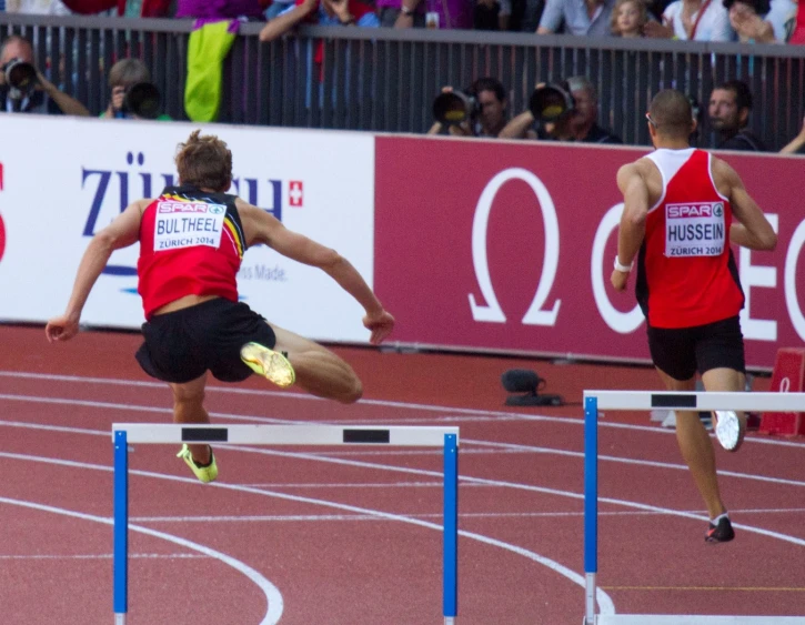 two athletes race over an obstacle