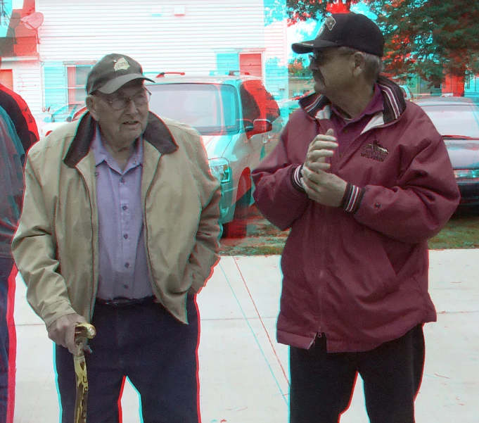 two men talk outside near a red fire hydrant