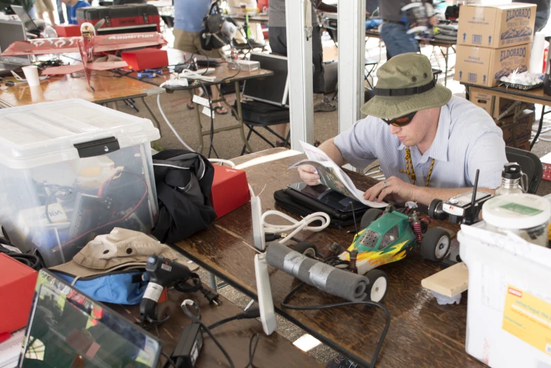 a man is working on a cell phone at a cluttered desk