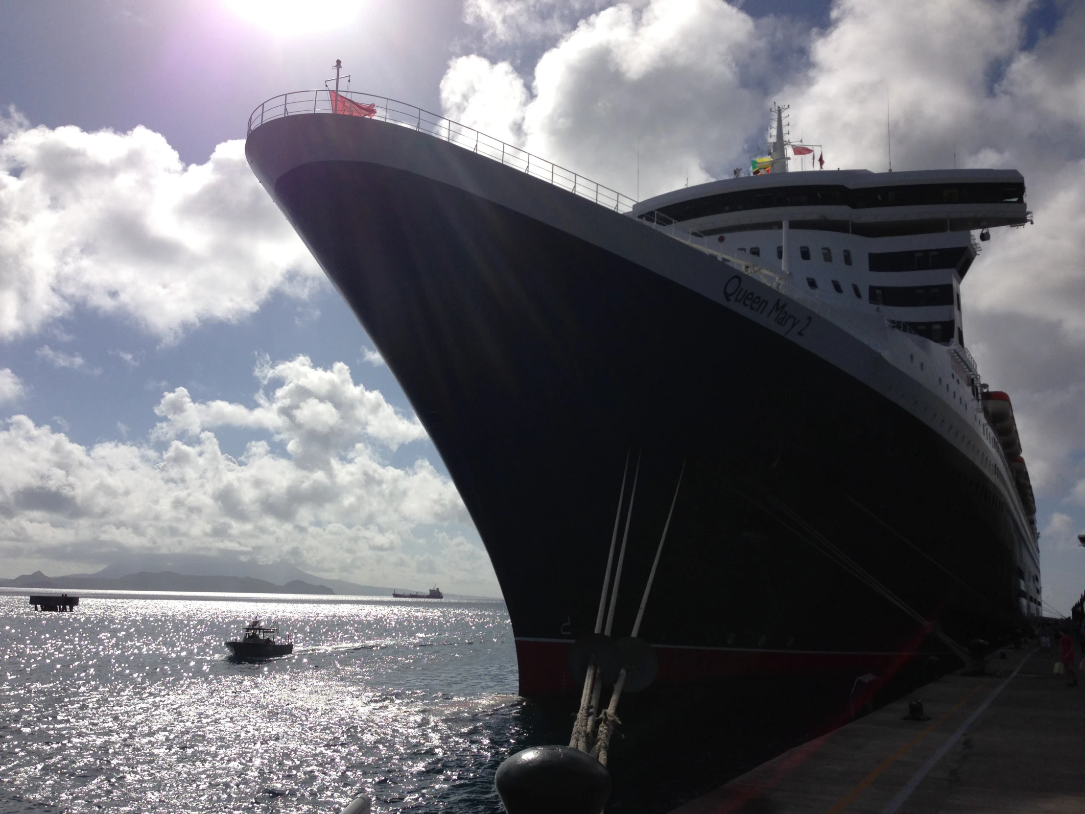 a cruise ship docked with a boat in the distance