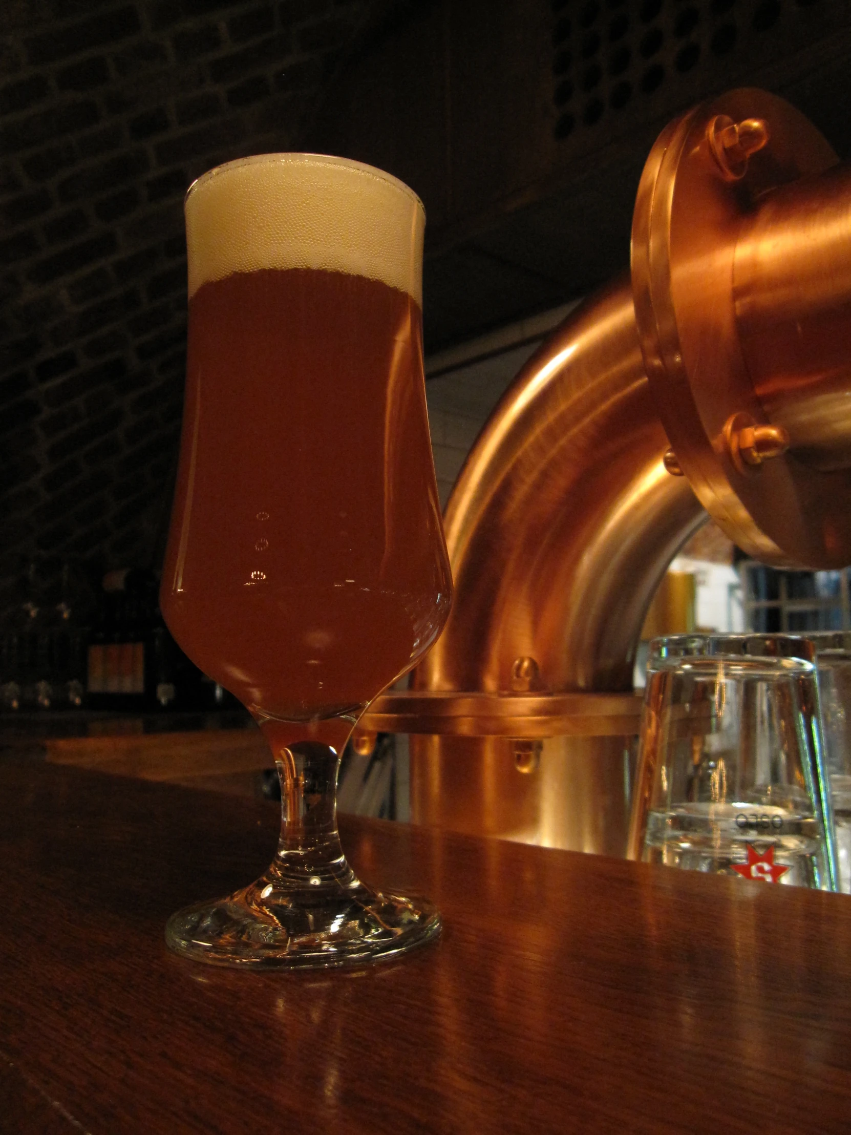 a large glass of beer on a bar