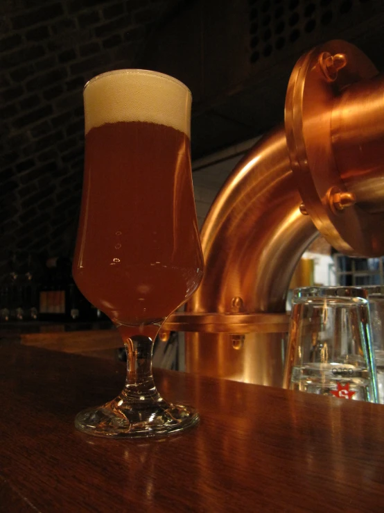 a large glass of beer on a bar