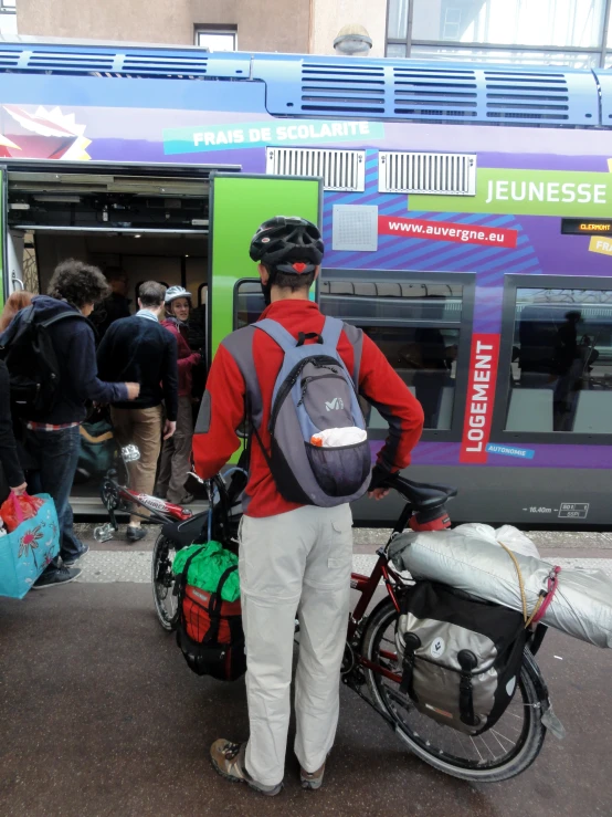 the man is standing next to his bicycle