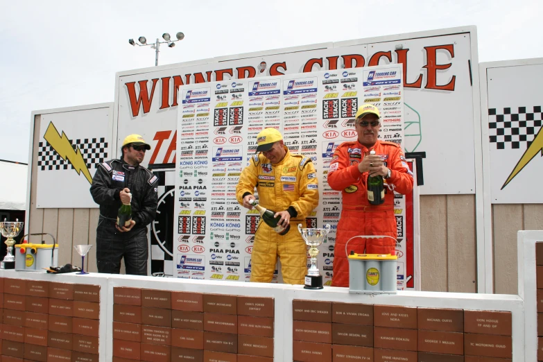 two men are sitting next to a race winner