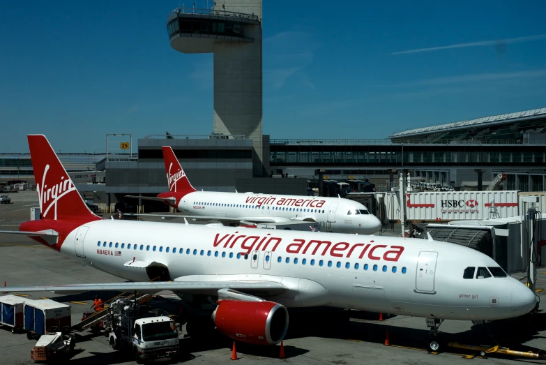 two white and red airplanes are parked at an airport